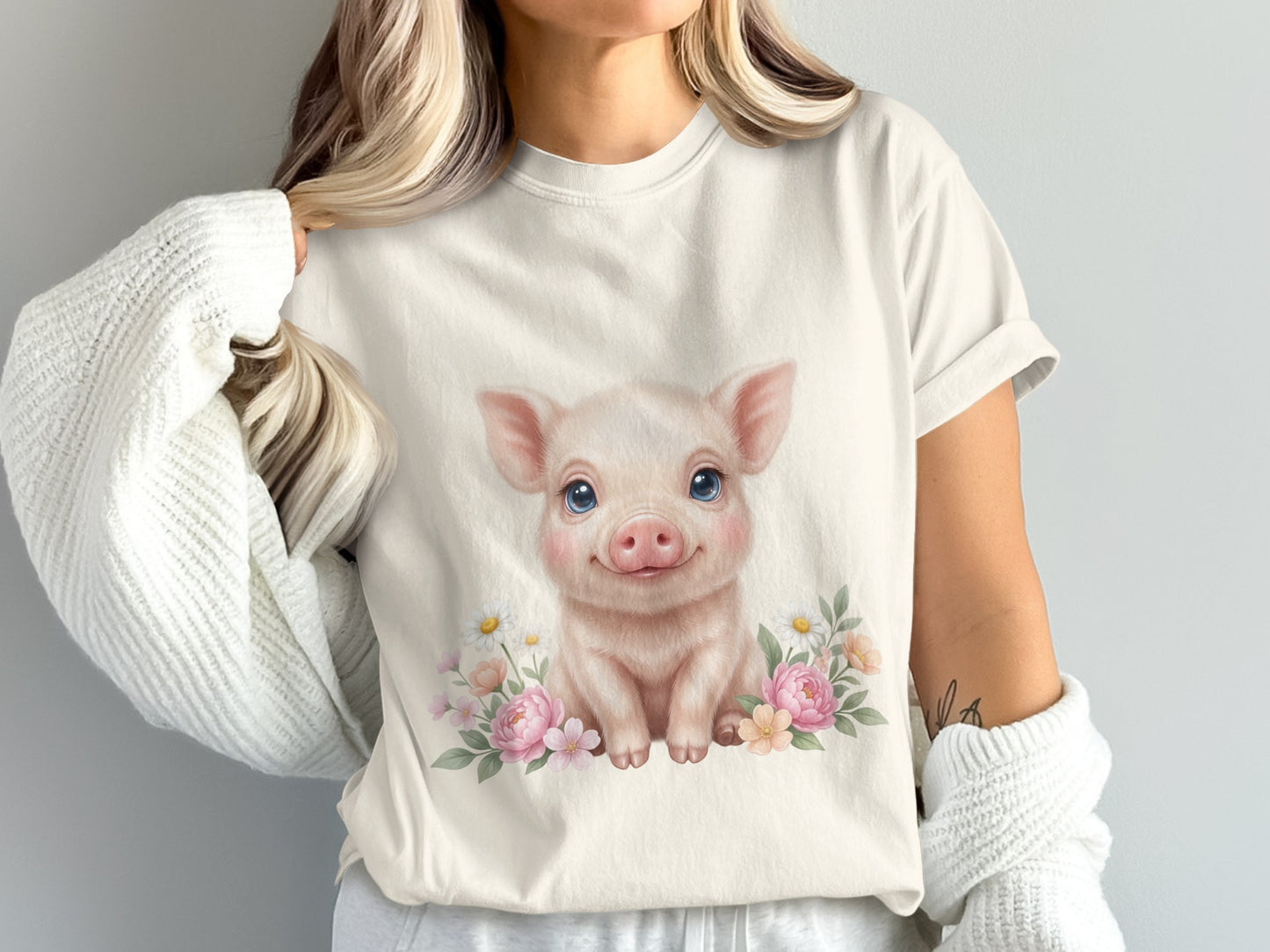 White t-shirt with a cute cartoon pig surrounded by flowers.