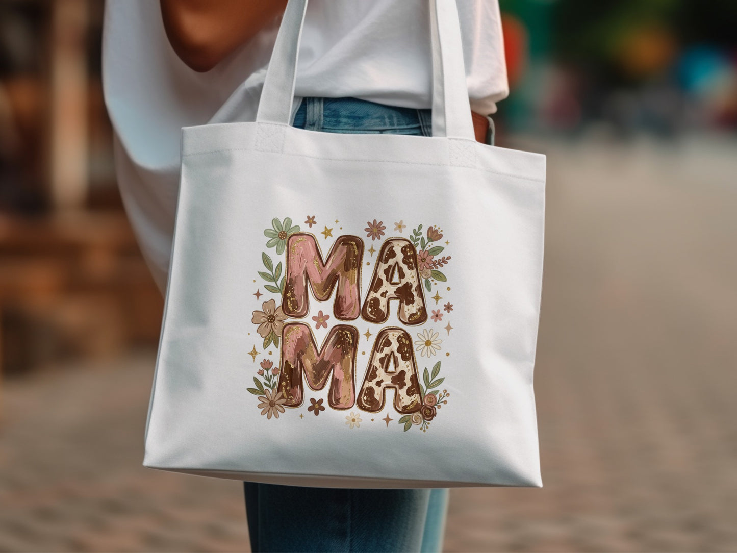 White tote bag with "Mama" text in floral and cow print letters.