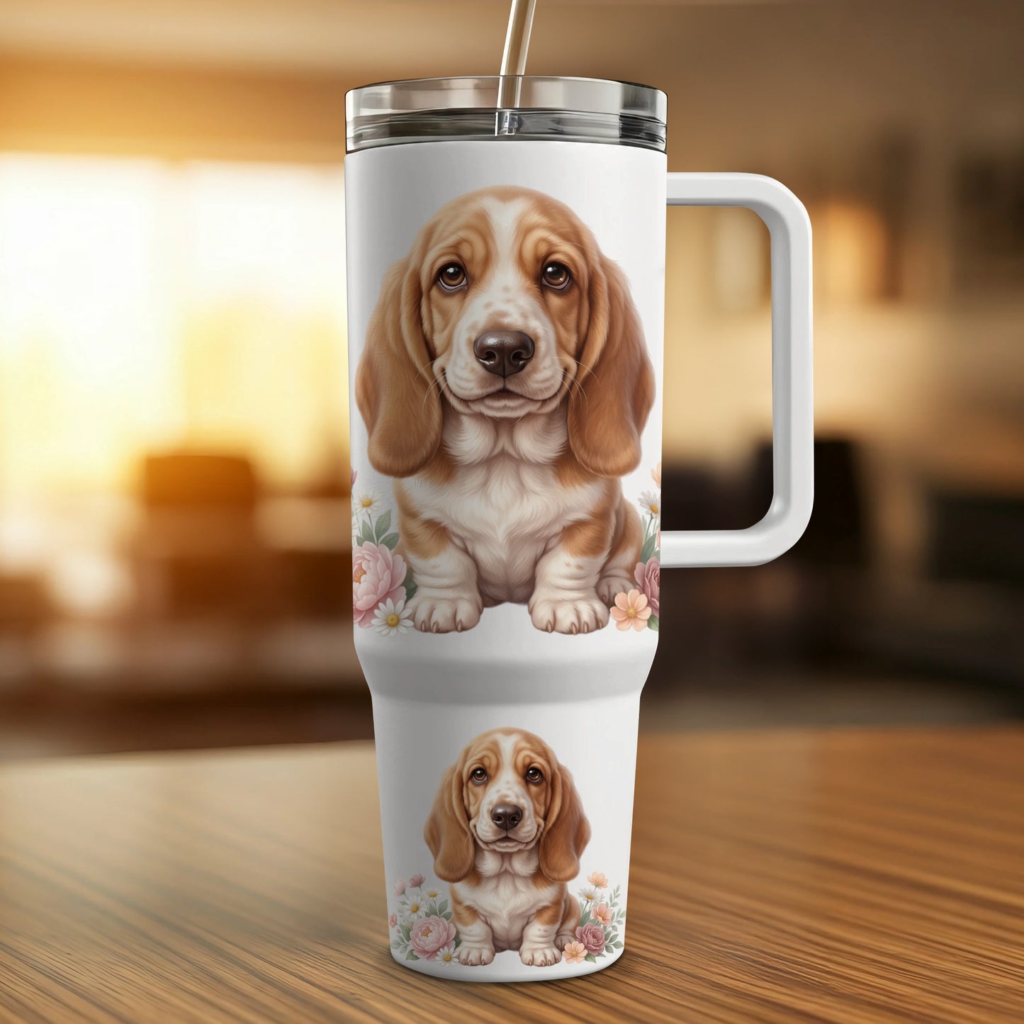 Two Basset Hound puppies sit amidst pink flowers on a white insulated tumbler.