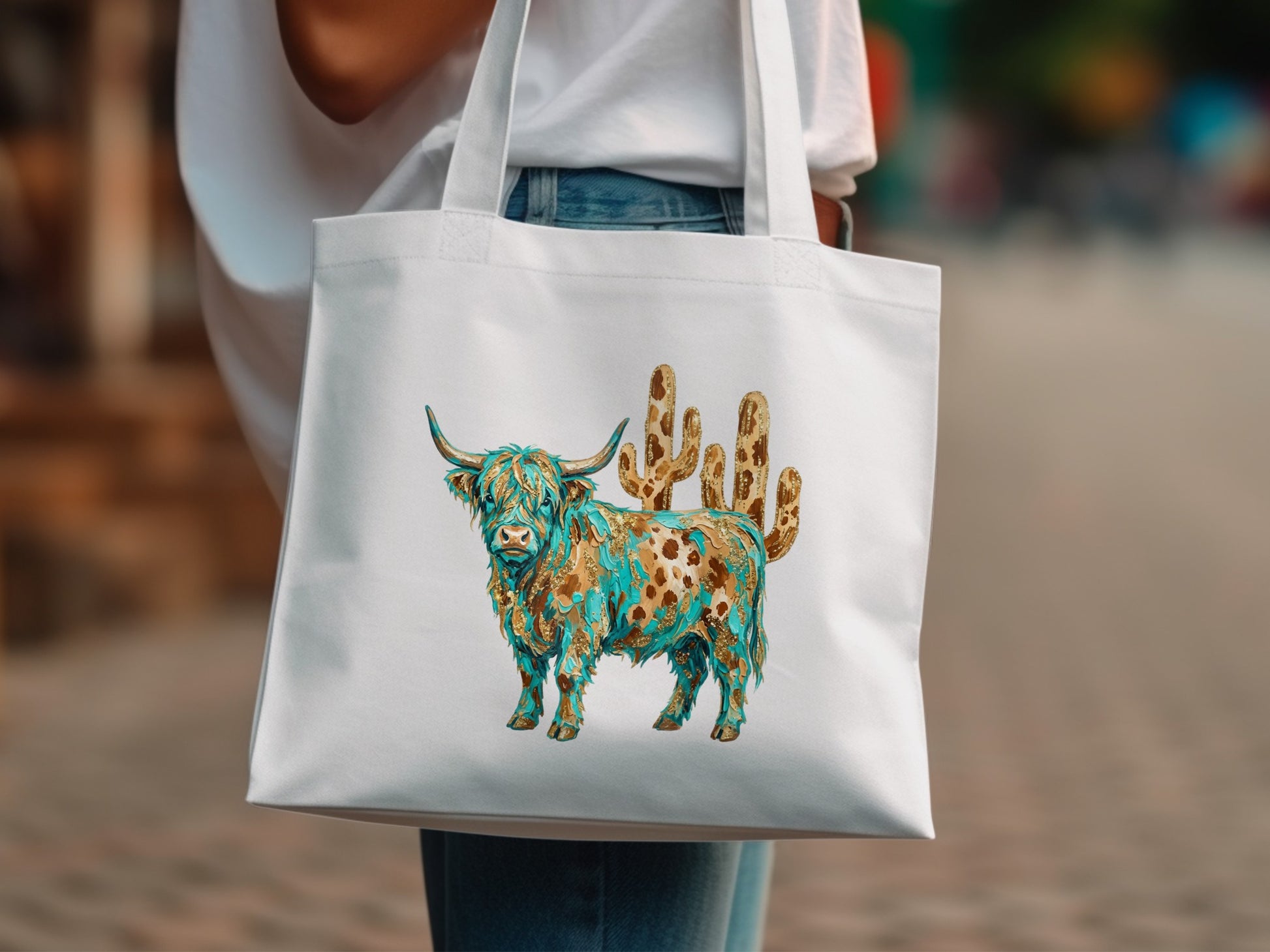 White tote bag featuring a detailed watercolor Highland cow and cactus design.