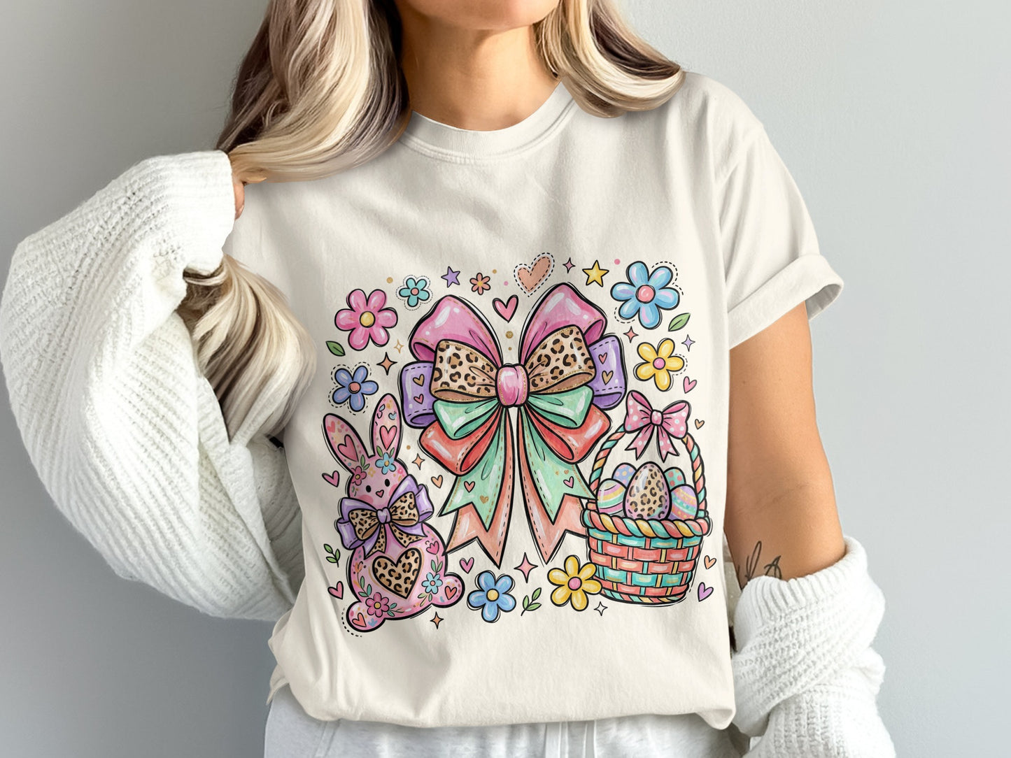 Easter graphic with bunny, bow, and basket on a cream t-shirt.