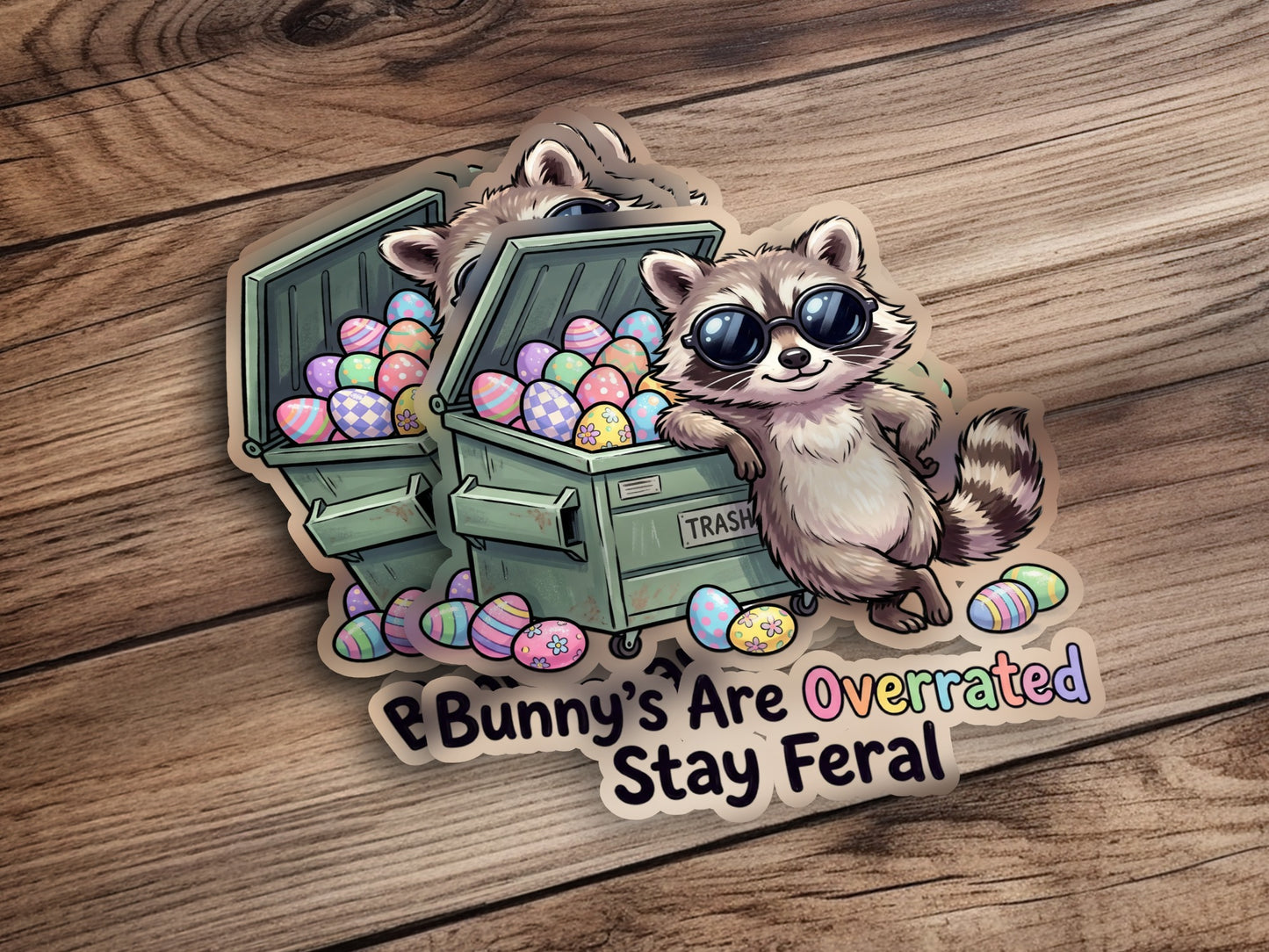Raccoon leaning on trash can overflowing with Easter eggs, text says "Bunny's Are Overrated Stay Feral".