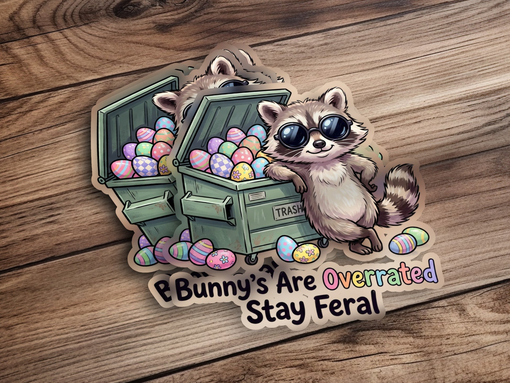 Raccoon leaning on trash can overflowing with Easter eggs, text says "Bunny's Are Overrated Stay Feral".