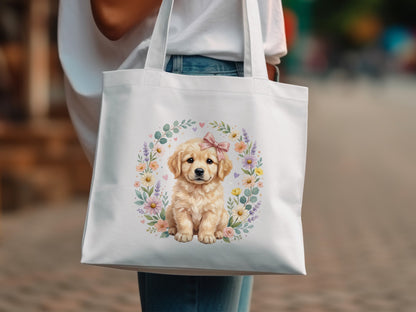 Golden retriever puppy wearing a pink bow, surrounded by floral wreath, on white tote bag.