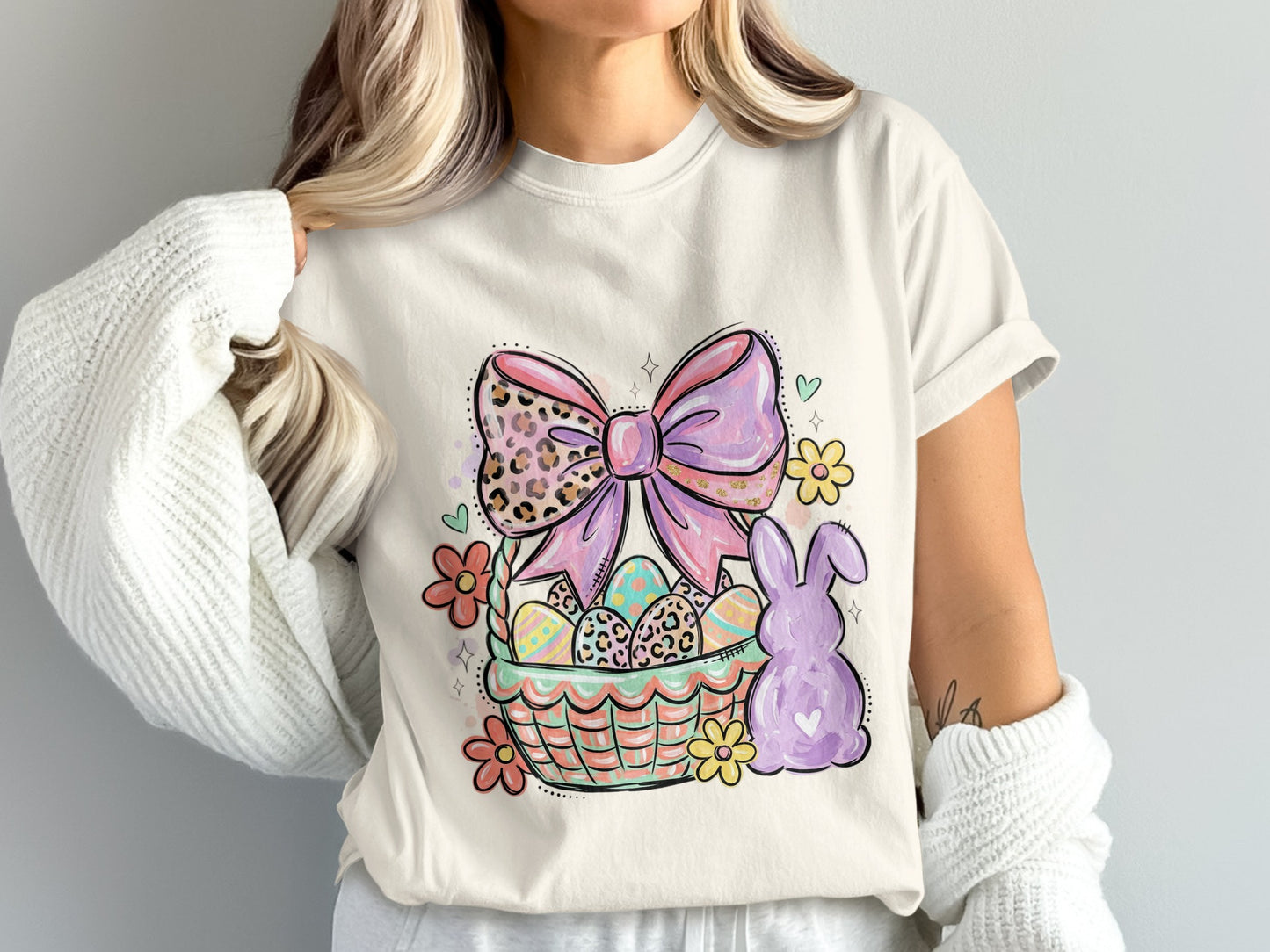 Easter basket with eggs, bow, and bunny graphic on a cream t-shirt.