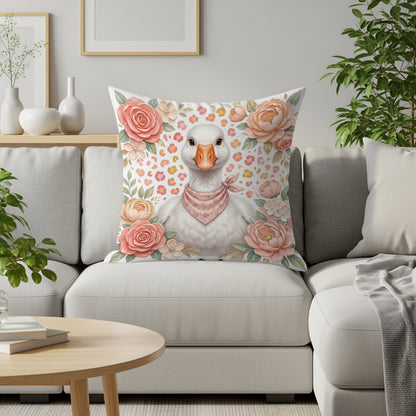 Goose with pink bandana on floral pillow on couch.