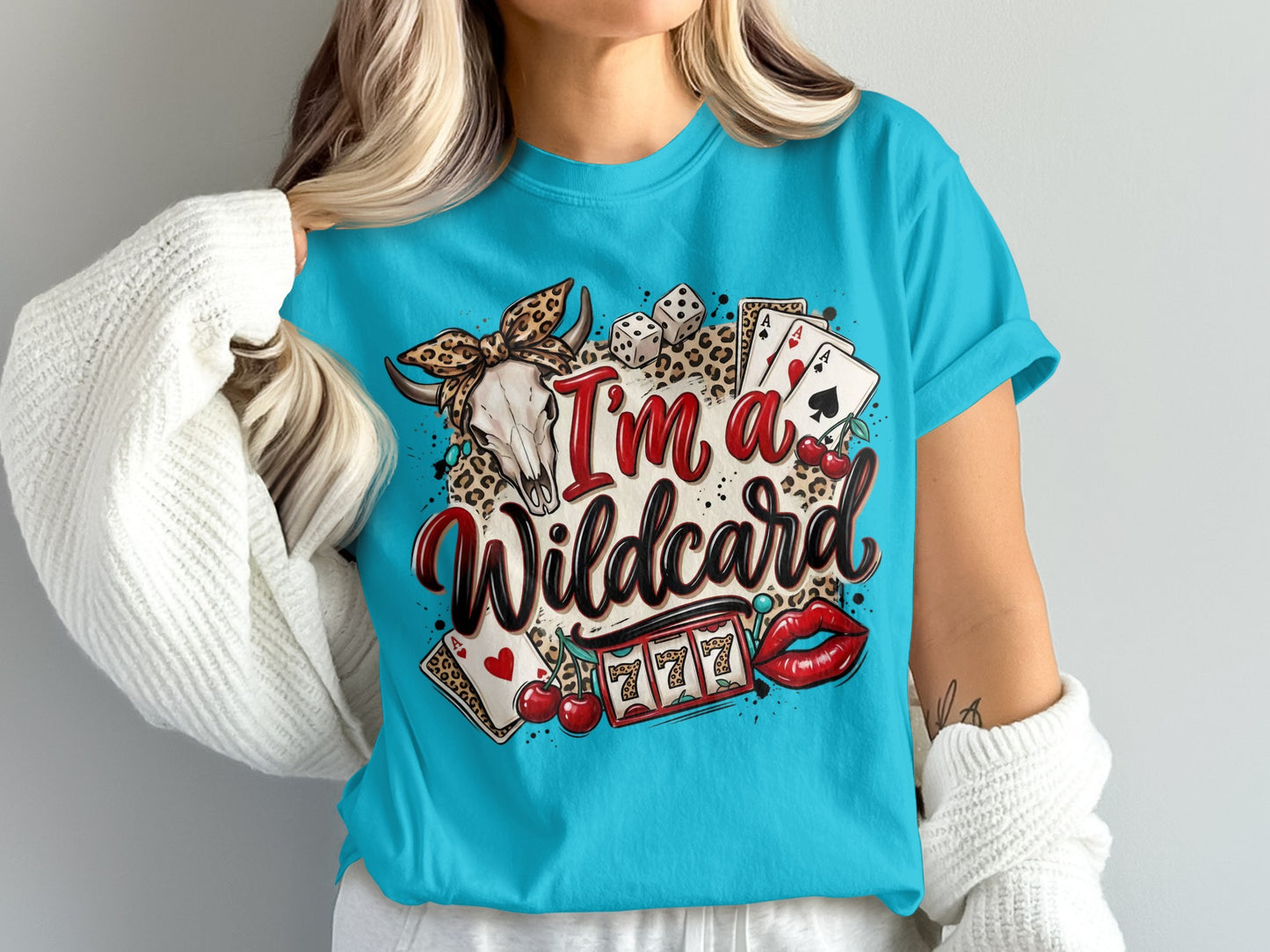 Woman wearing a blue t-shirt with "I'm a Wildcard" text, skull, dice, and cherries.