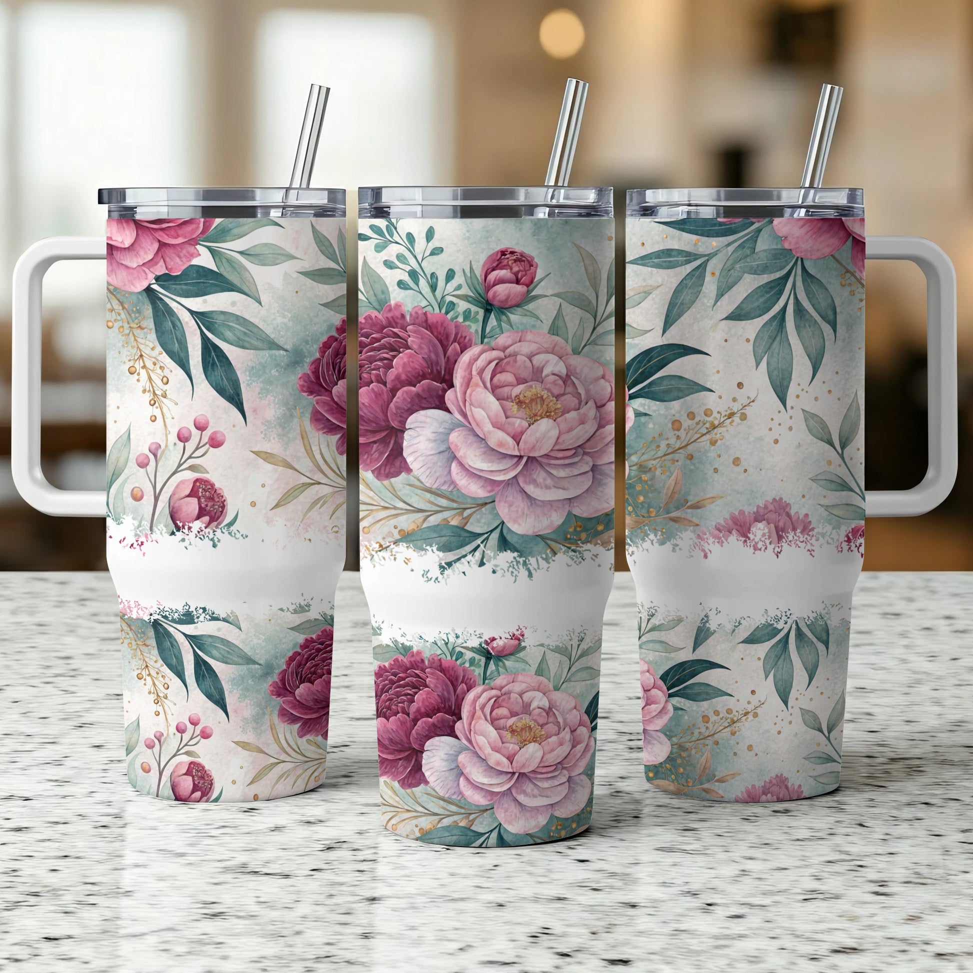 Three floral patterned tumblers with straws and handles on a speckled countertop.