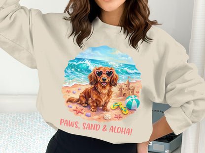 Dachshund wearing heart sunglasses on beach with sandcastle, "Paws, Sand & Aloha!" text.