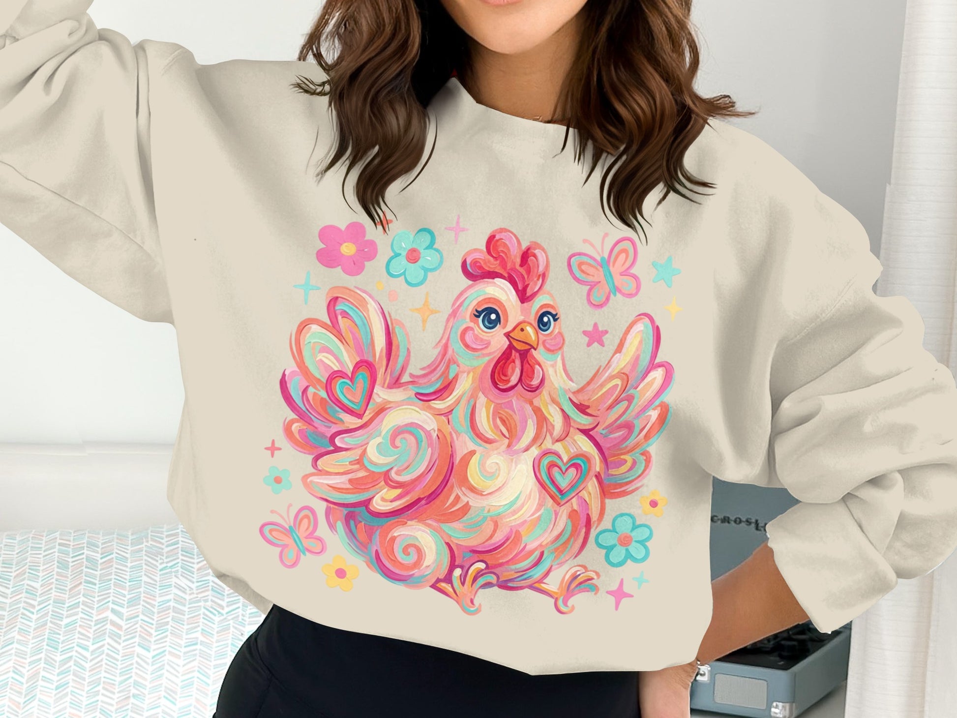 Colorful cartoon chicken with hearts and butterflies on a cream sweatshirt.