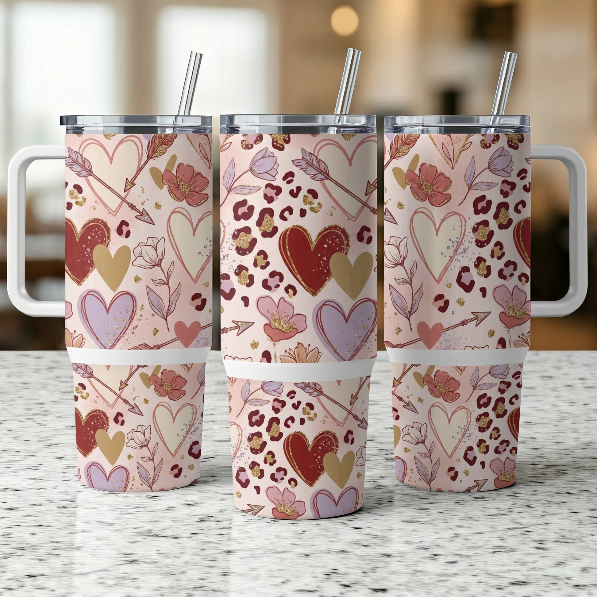 Three tumblers with hearts, arrows, and floral patterns.