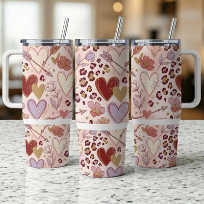 Three tumblers with hearts, arrows, and floral patterns.
