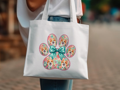 White tote bag with a paw print of Corgis and floral accents.