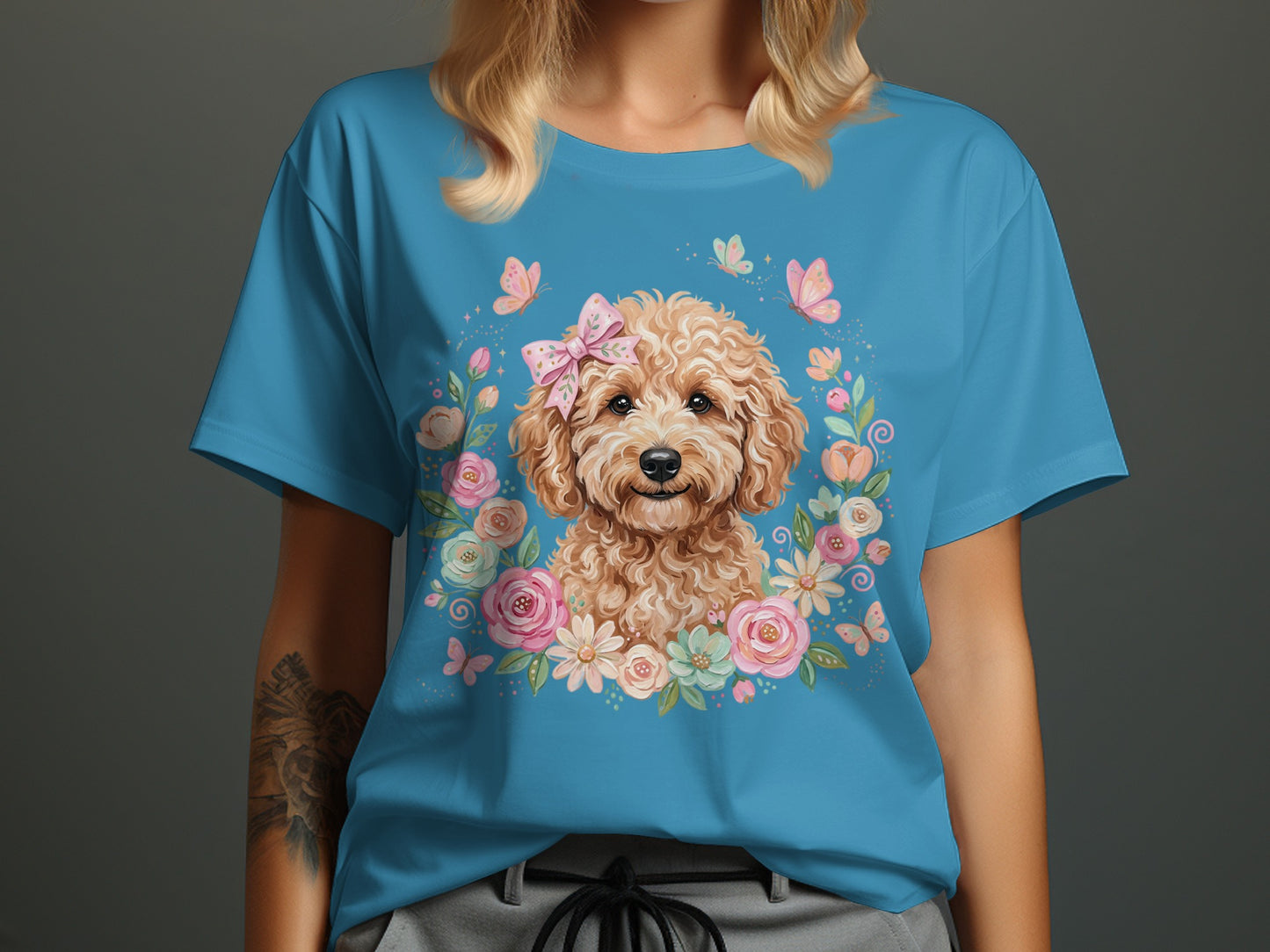 Blue t-shirt with doodle dog wearing a pink bow in a floral wreath.