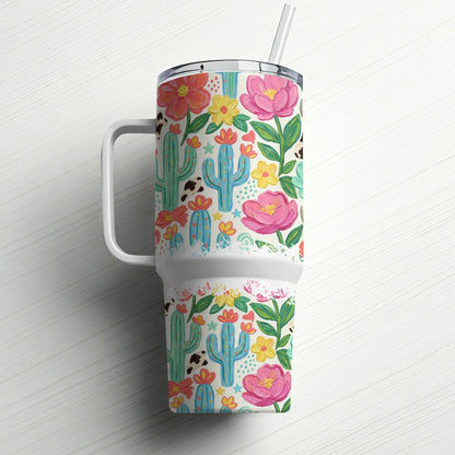 Tumbler with cactus, cow, and floral pattern and a straw.