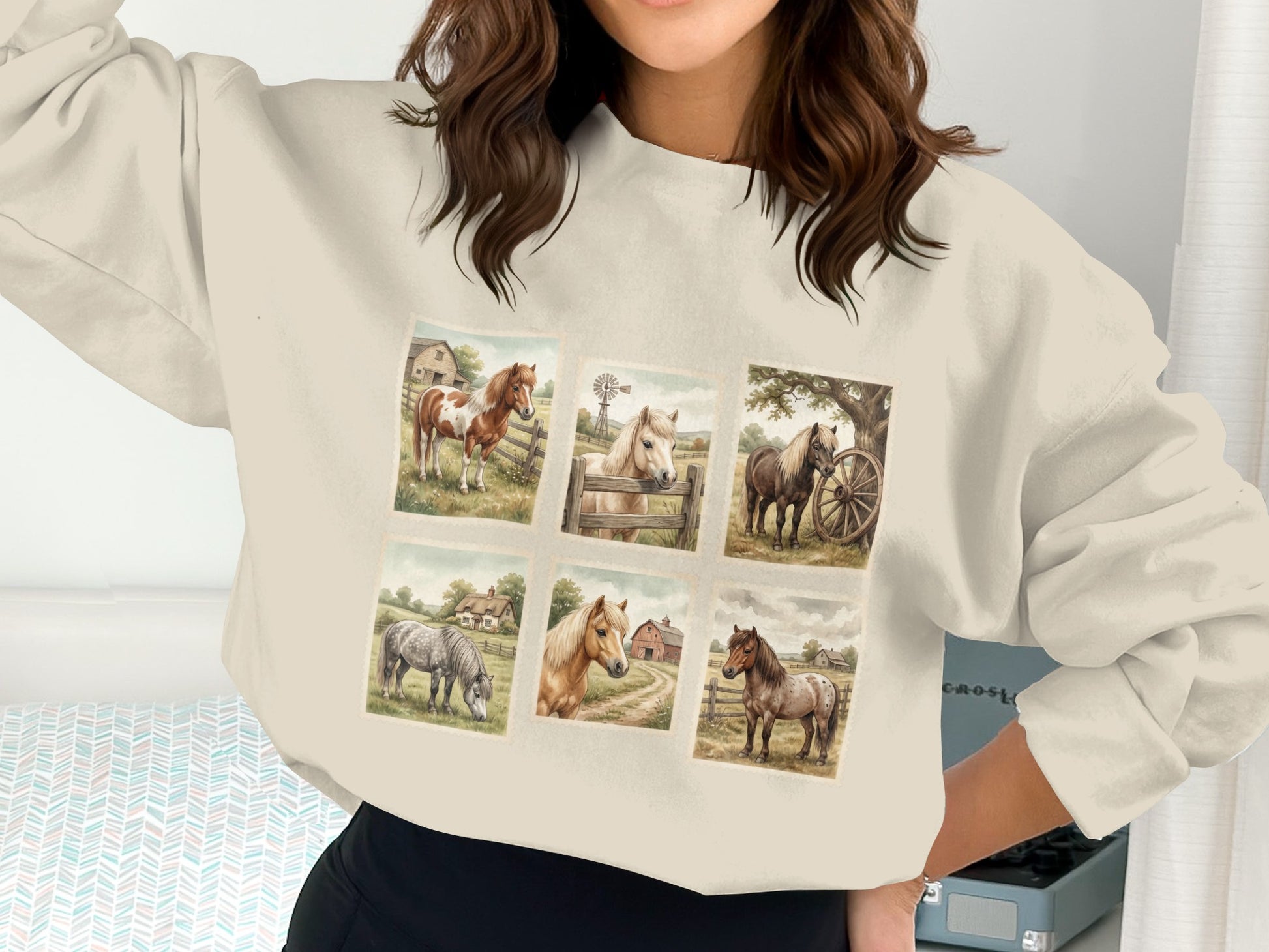 Six square illustrations of horses in pastoral settings on a cream sweatshirt.
