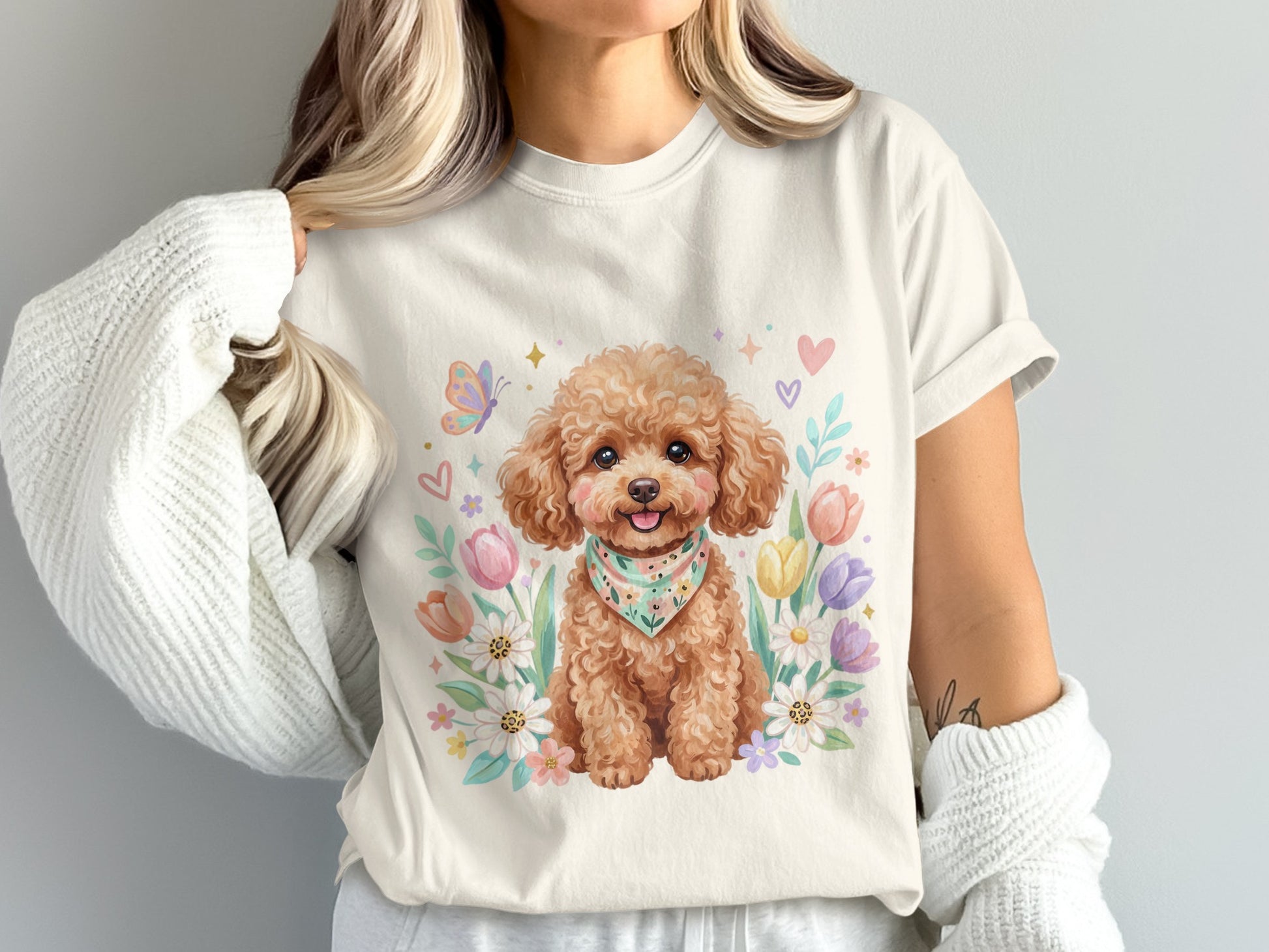 Cream t-shirt with a poodle wearing a bandana surrounded by flowers and butterflies.