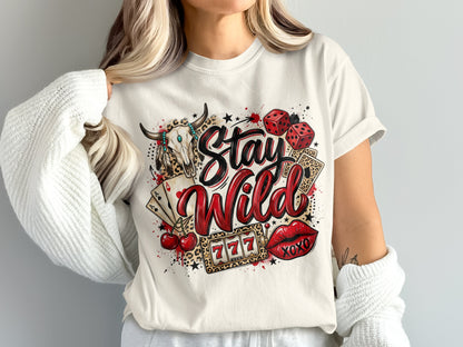 White t-shirt with "Stay Wild" in red and leopard print, featuring dice, cards, bull skull, and lips.