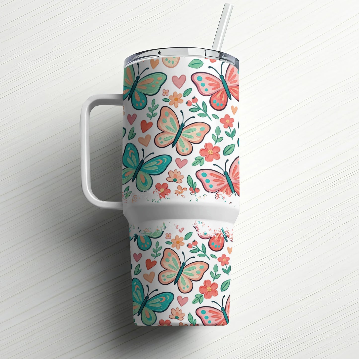 Tumbler with pink and teal butterflies, hearts, and floral pattern.