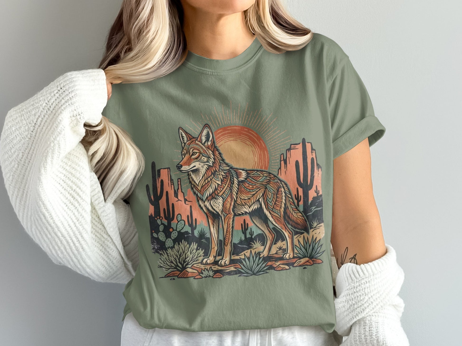 Desert landscape with coyote, cacti, and sun on a green t-shirt.