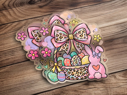 Easter basket with eggs, bunny ears, and bows on a wooden background.