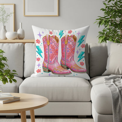 Pink cowboy boots with star and lightning bolt pattern on a cushion.