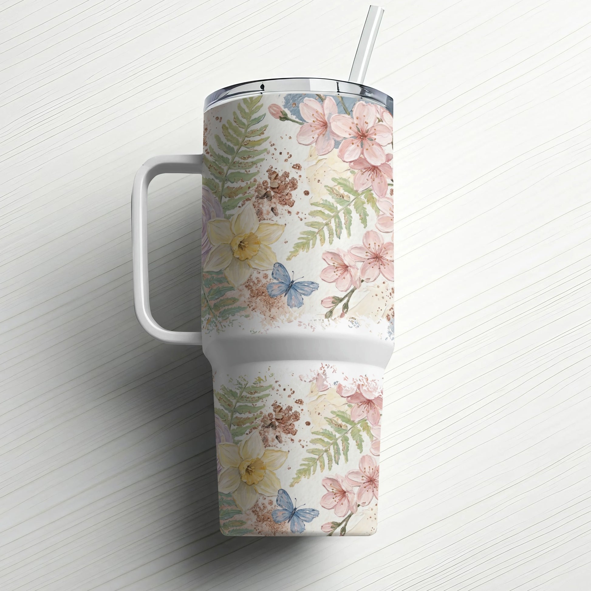 Tumbler with floral and butterfly pattern and straw.