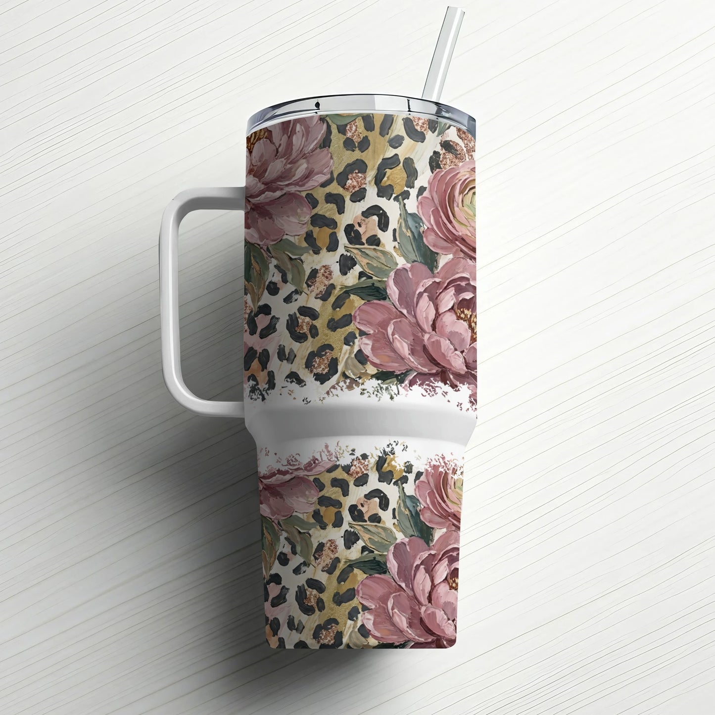 Tumbler with floral and leopard print patterns, featuring a white handle and straw.