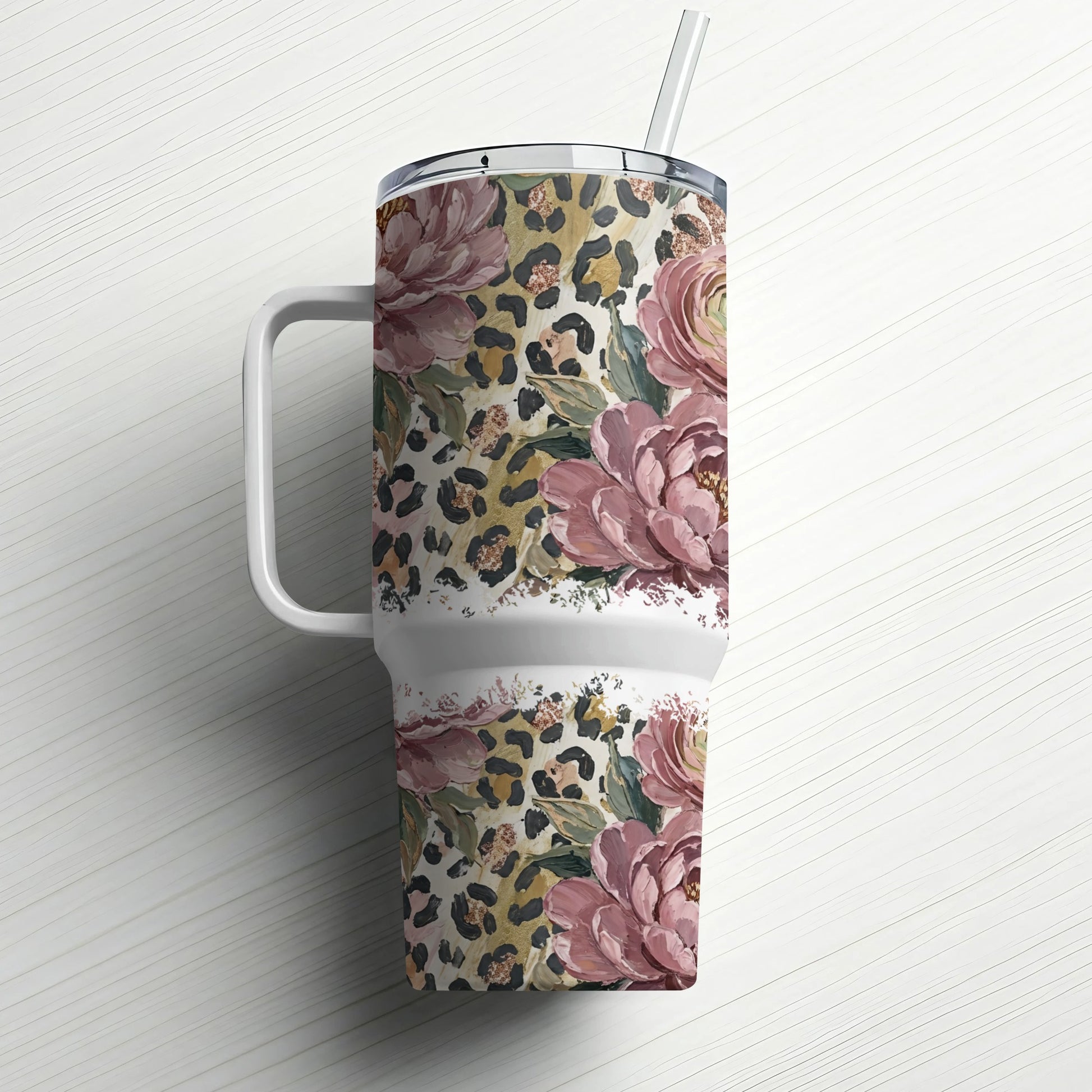 Tumbler with floral and leopard print patterns, featuring a white handle and straw.