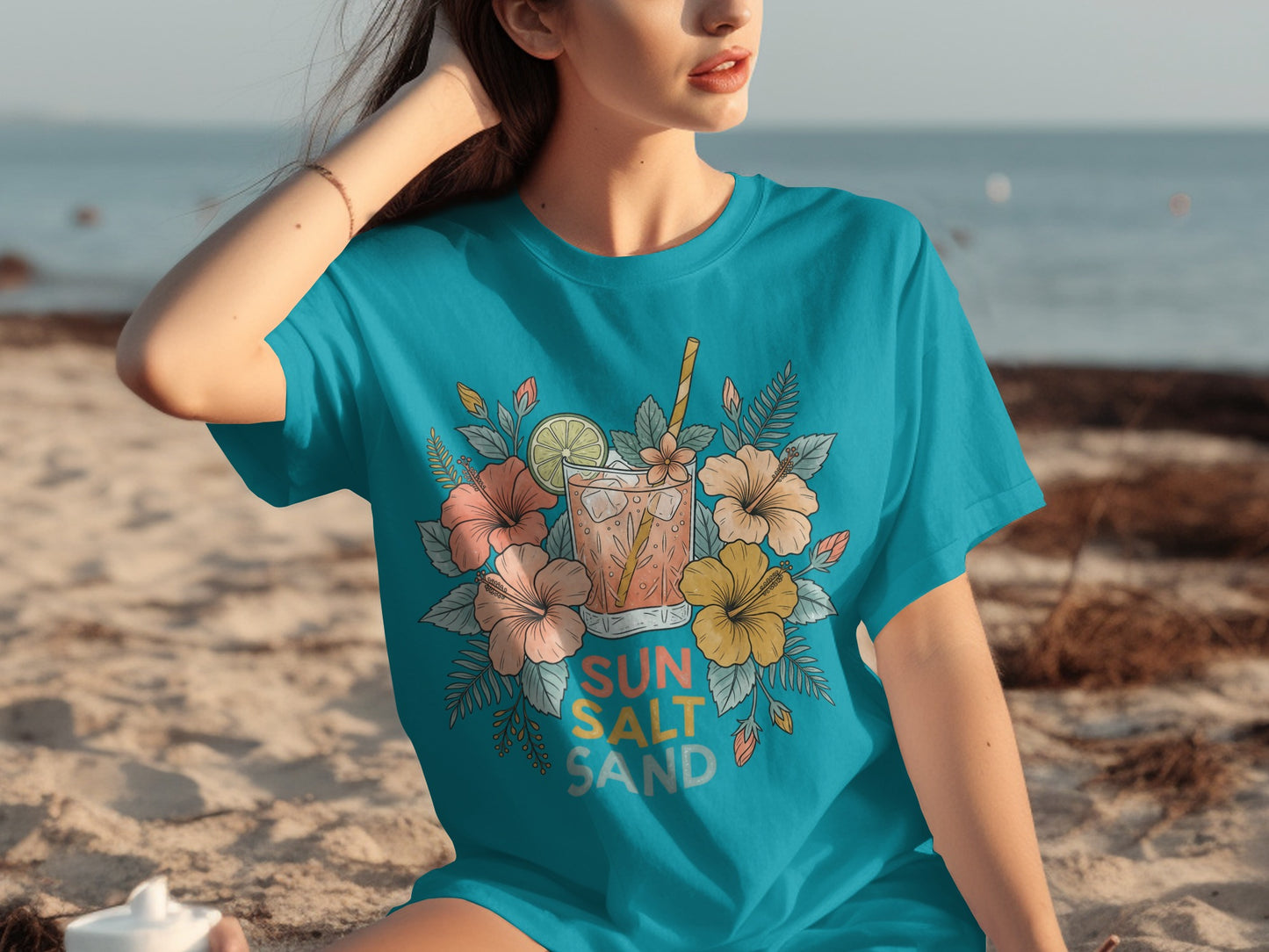 Turquoise t-shirt with floral drink illustration and "SUN SALT SAND" text.