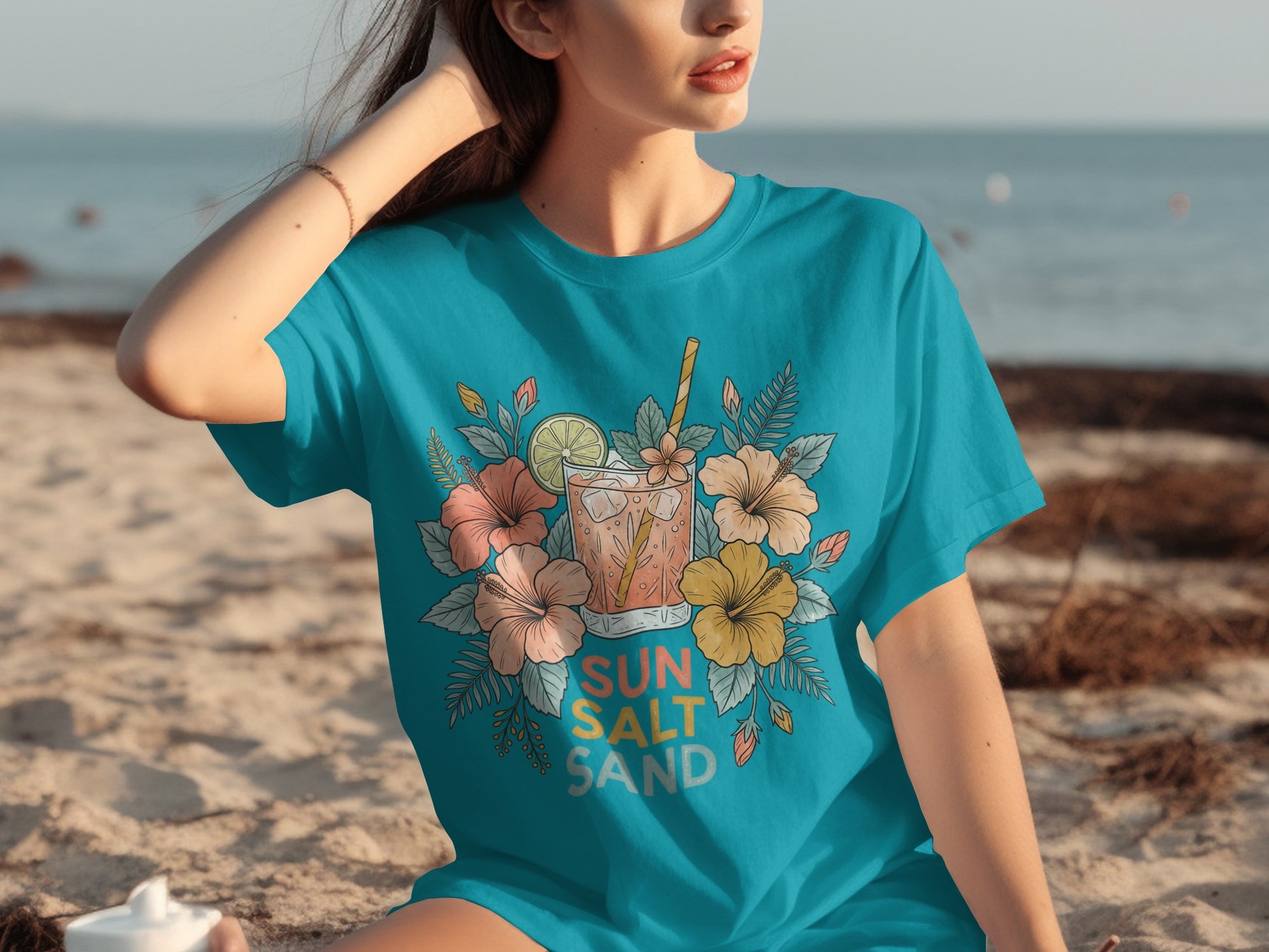 Turquoise t-shirt with floral drink illustration and "SUN SALT SAND" text.