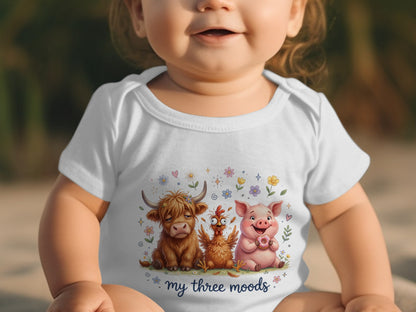 Baby wearing white bodysuit with farm animals and "my three moods" text.