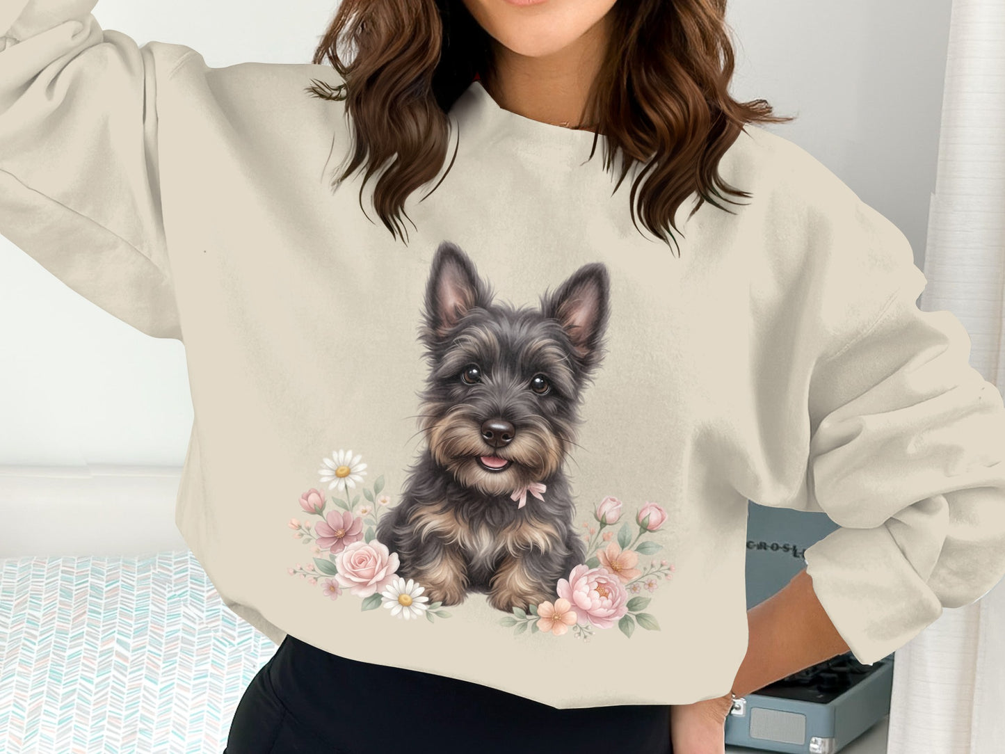 Sweater with a watercolor painting of a small, dark dog surrounded by flowers.