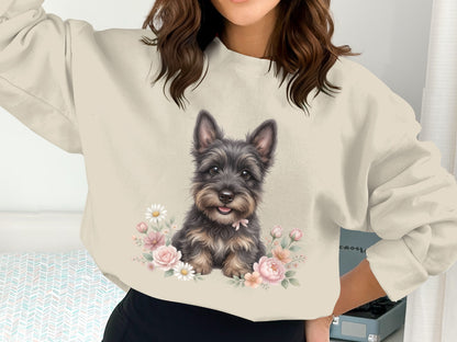 Sweater with a watercolor painting of a small, dark dog surrounded by flowers.