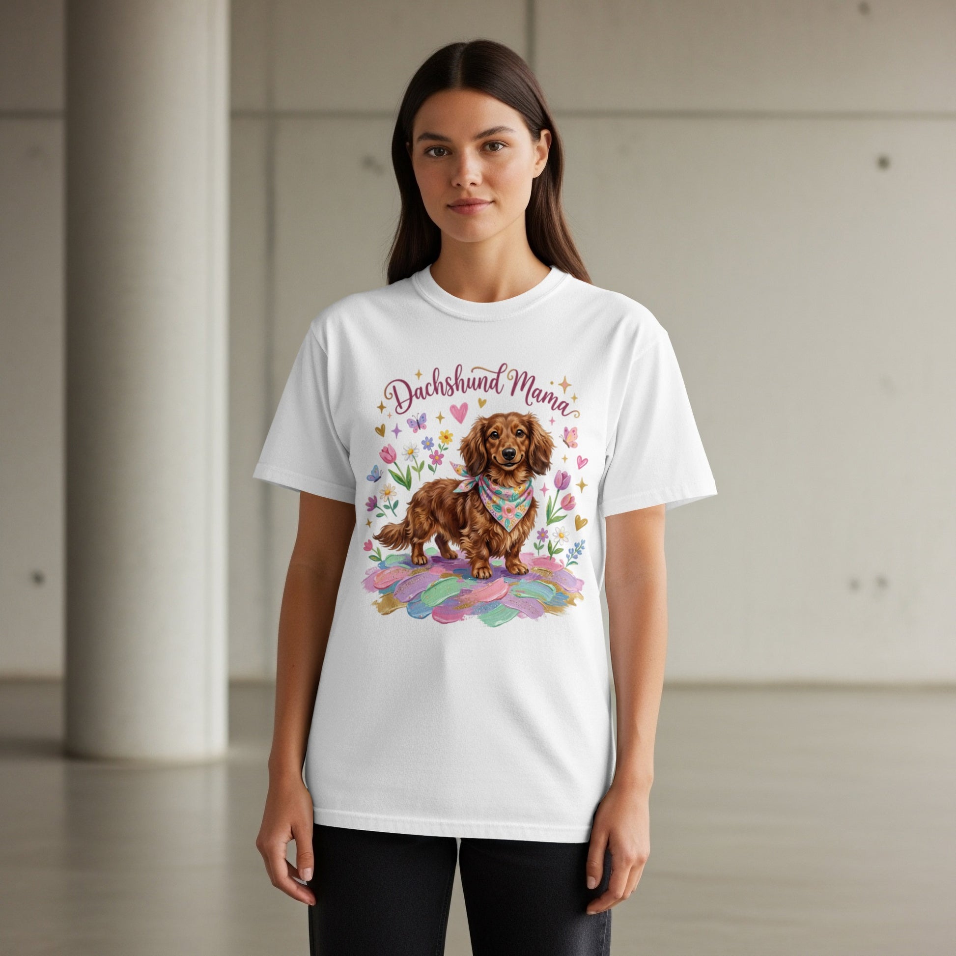White t-shirt with a watercolor dachshund wearing a bandana, surrounded by feathers and flowers.