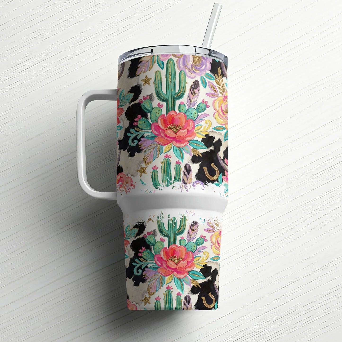 Floral, cactus, and cow print tumbler with straw and handle.