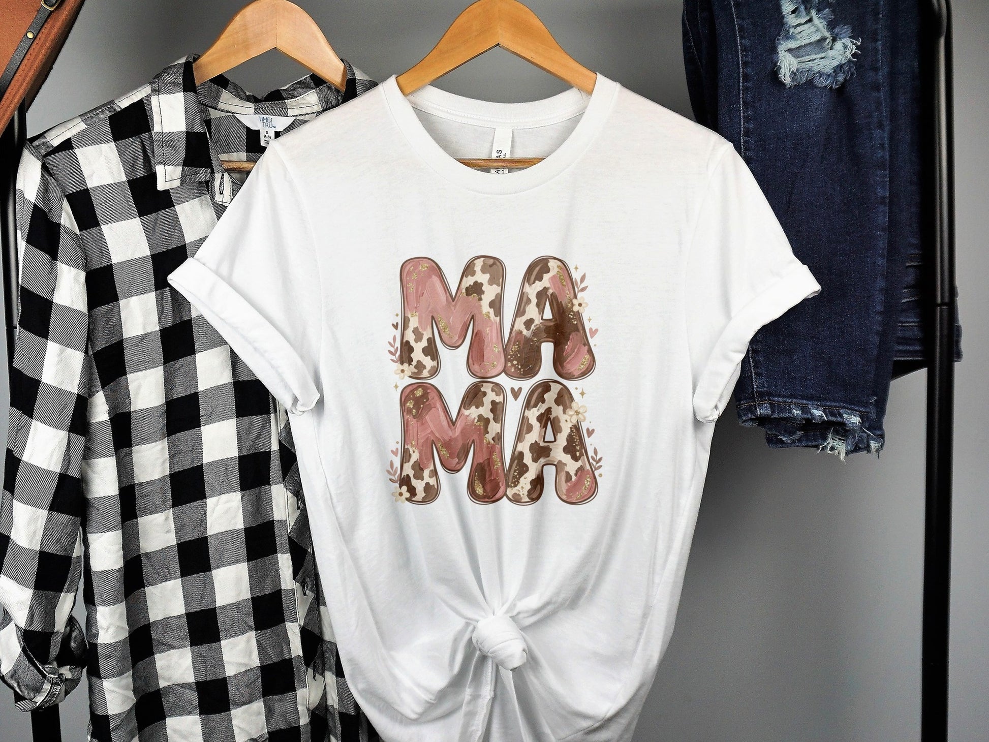 White t-shirt with "Mama" in a floral and cow print design.