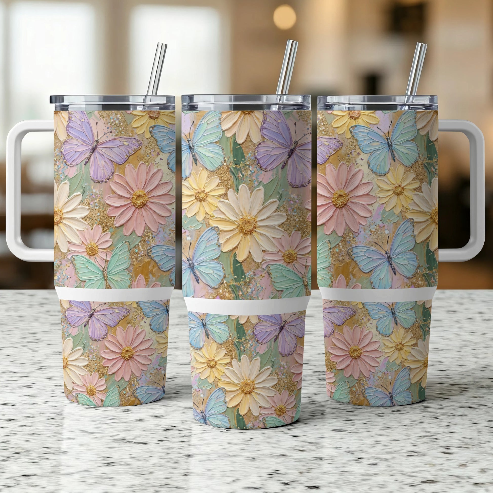 Three pastel floral and butterfly patterned tumblers with handles and straws.