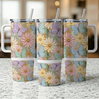 Three pastel floral and butterfly patterned tumblers with handles and straws.