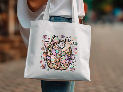 White tote bag with Easter basket illustration of eggs, bunny, bows, and hearts.