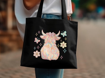 Black tote bag with a pastel fluffy Highland cow and floral design.