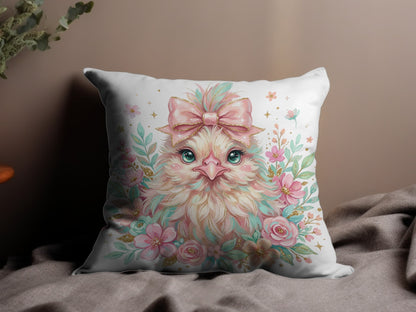 Fluffy chick with pink bow and floral accents on decorative pillow.