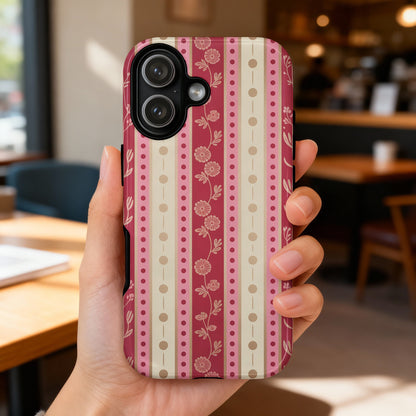 Hand holding iPhone with pink and beige floral striped pattern.