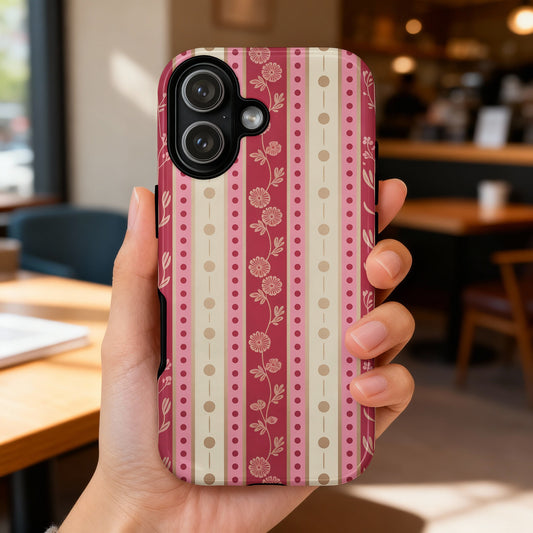 Hand holding iPhone with pink and beige floral striped pattern.