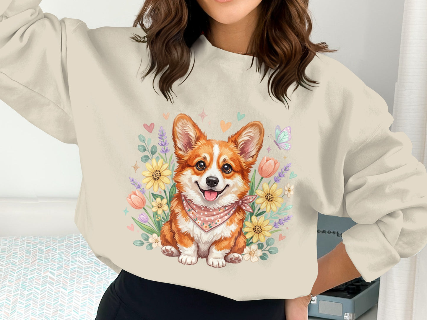Cream sweatshirt with a smiling corgi wearing a bandana surrounded by flowers.