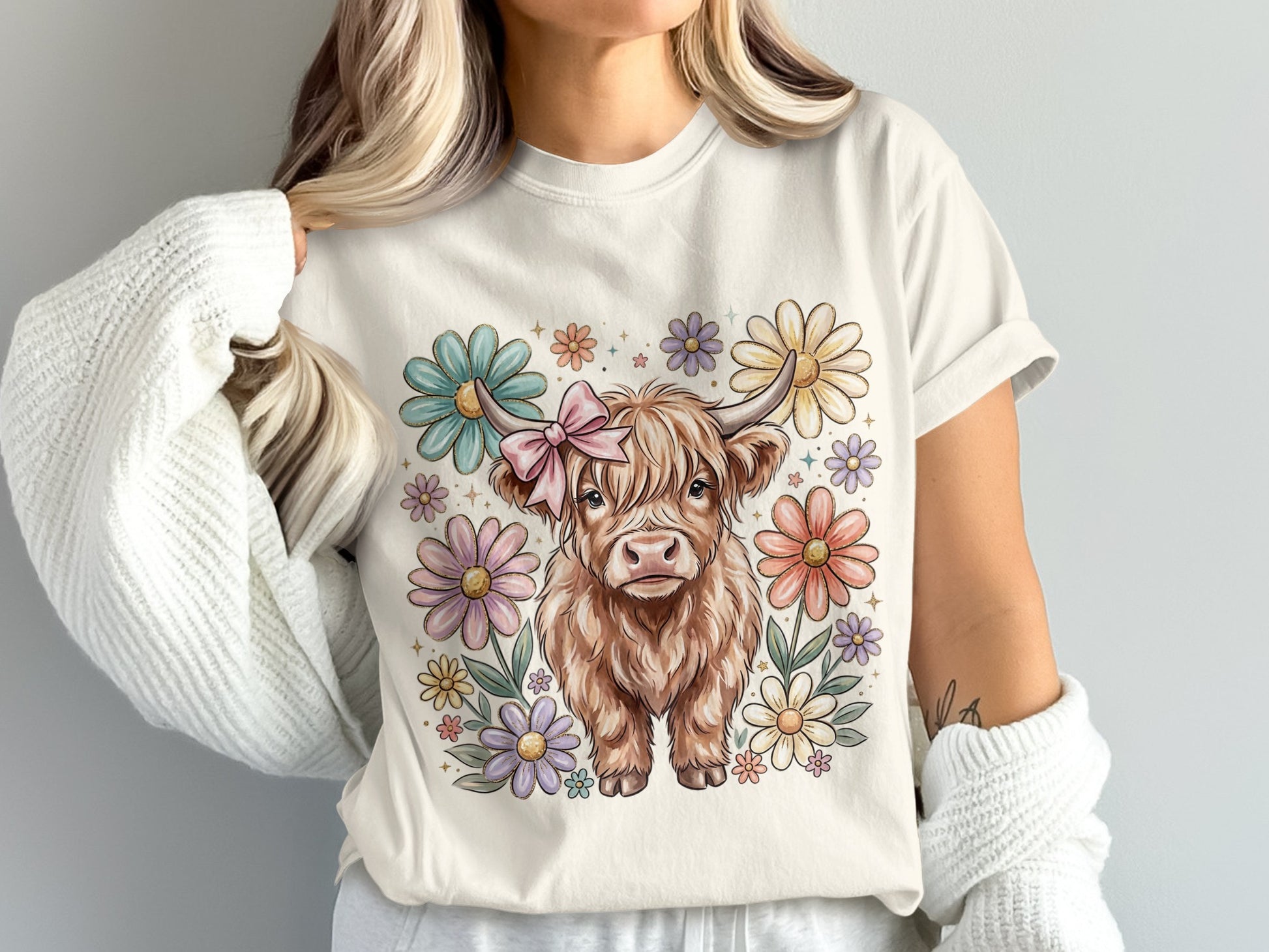 Cream t-shirt with cartoon Highland cow and colorful flowers.