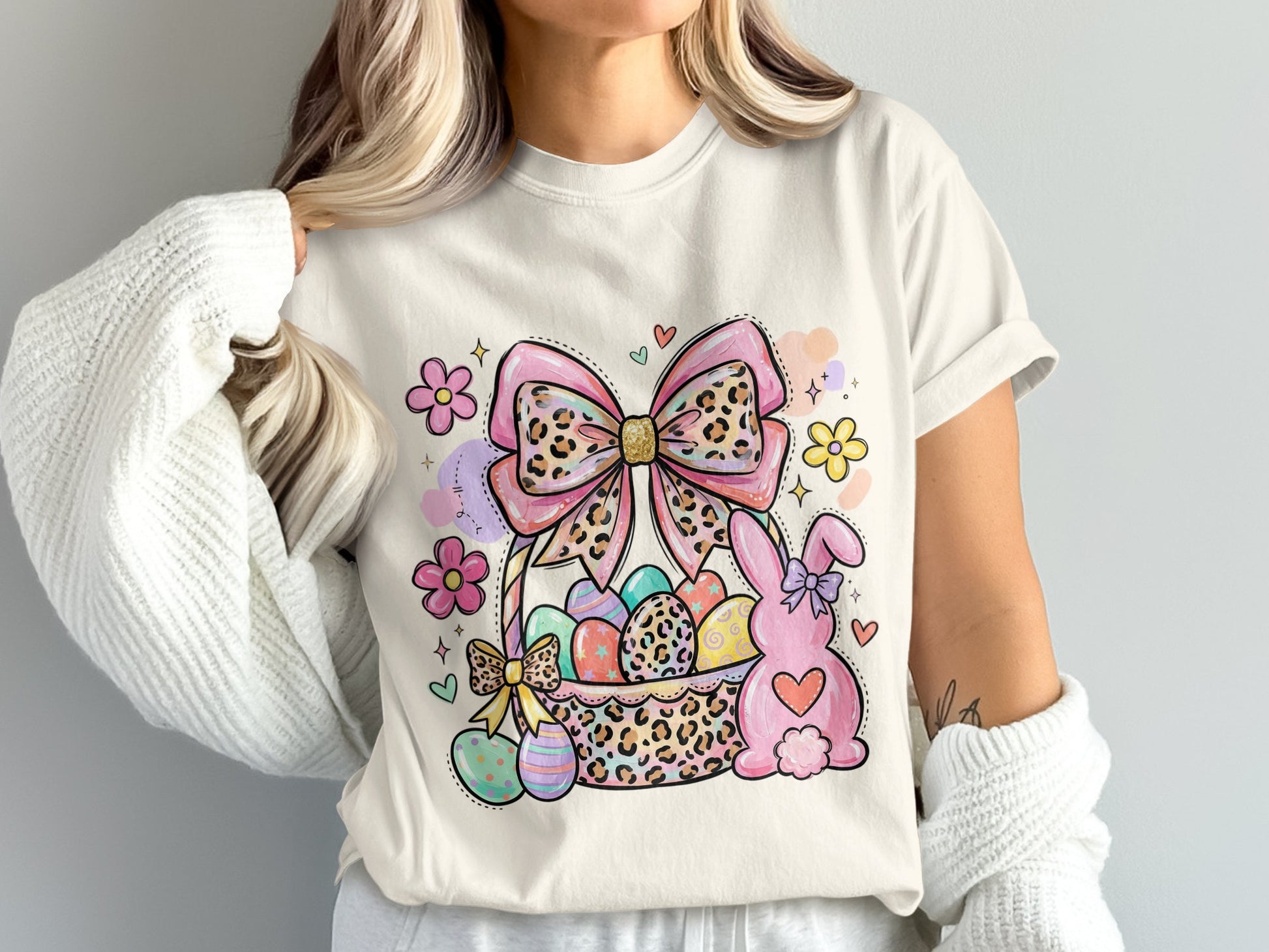 Easter basket with decorated eggs, a bunny, and a bow on a t-shirt.