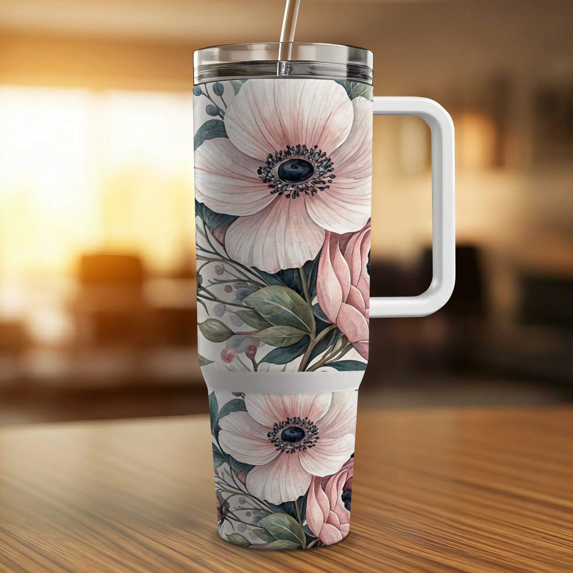 Tumbler with pink floral pattern and handle on a wooden surface.