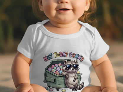 Baby wearing white bodysuit with "Not Today Bunny" and raccoon by dumpster.