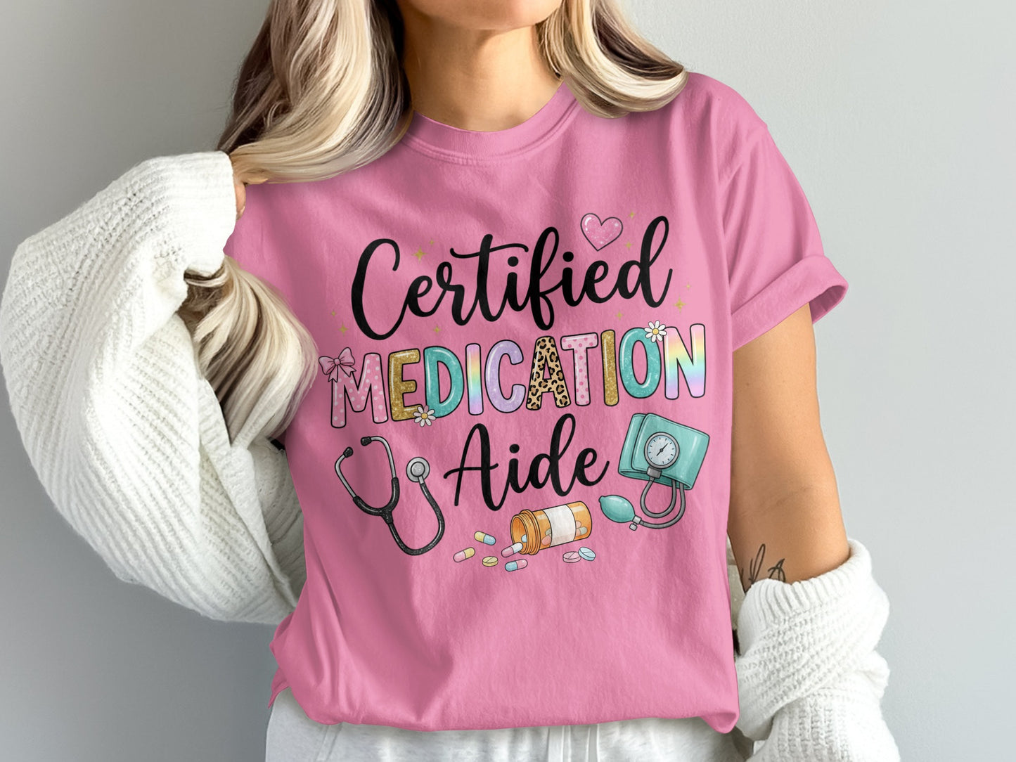 Pink t-shirt with "Certified Medication Aide" text and medical icons.